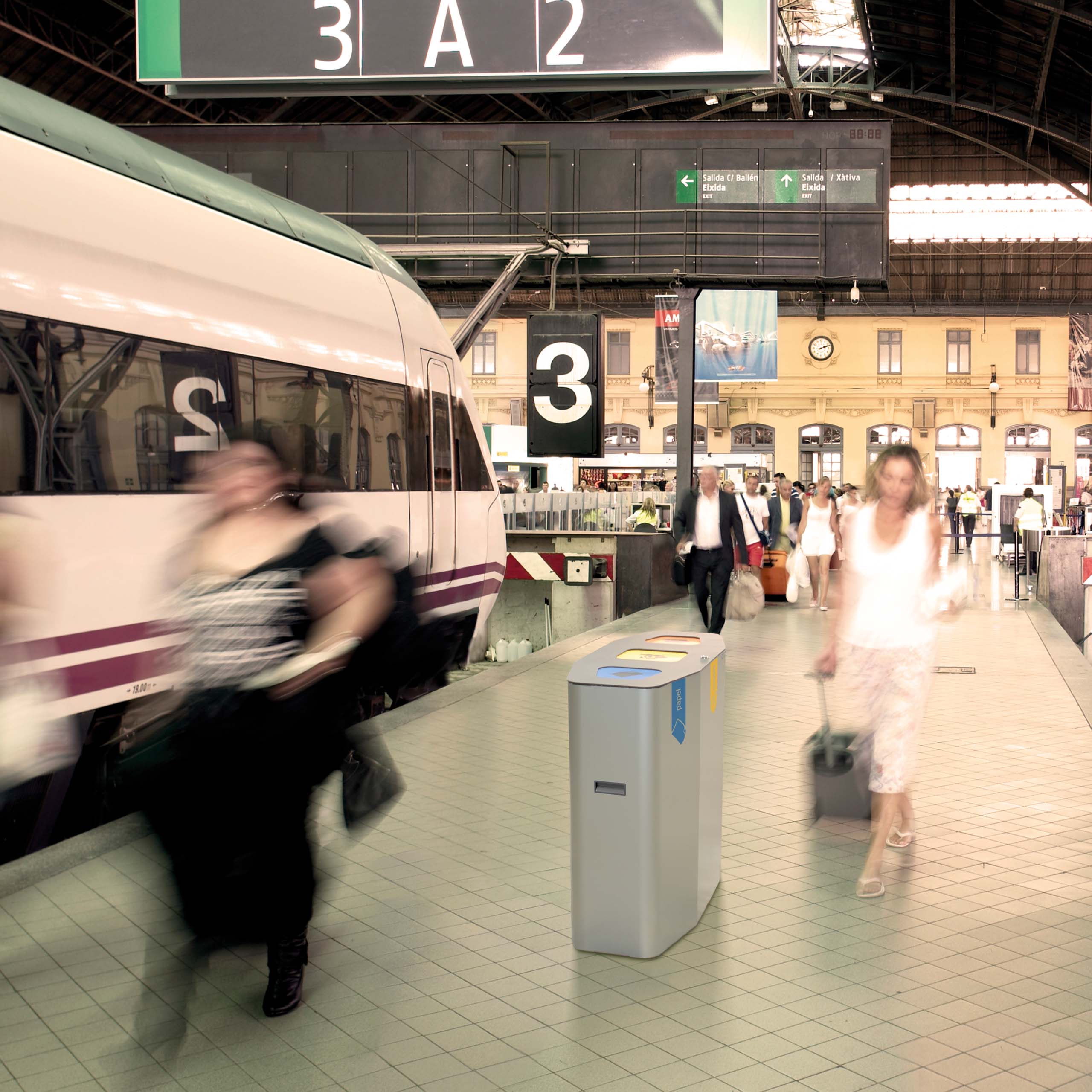 Belebter Bahnsteig in einem modernen Bahnhof mit vorbeigehenden Reisenden, Zug und farblich markierten Recyclingbehältern.